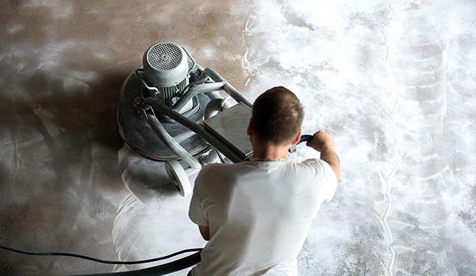 Professional polishing a concrete floor with high-speed grinder